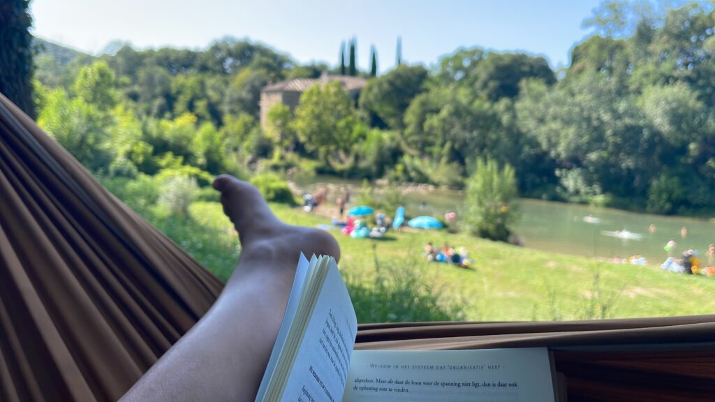 Guus van Zeijl personal life coach op vakantie in Frankrijk met een boek aan de rivier